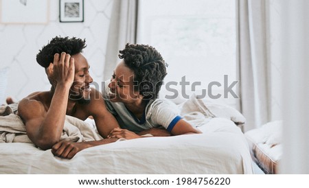 Cute happy black couple playing in bed