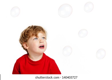 Cute Happy boy playing with bubbles shot in the studio on a white background.