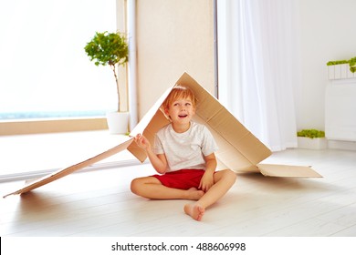 Cute Happy Boy Playing With Cardboard Box As With Toy House