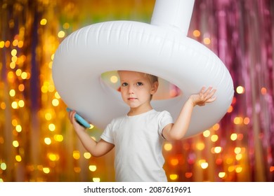 Cute Happy Child Toddler In Unicorn Pajamas Playing Jumping With Inflatable Unicorn On Colorful Bright Background, Pajama Theme Party, Rainbow Theme And Baby Emotions