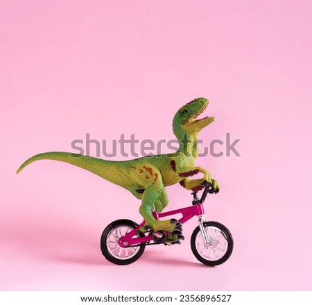 Cute happy dinosaur toy riding bicycle on pastel pink background. Cute eco friendly transport concept card.