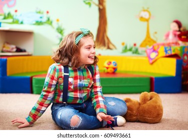 cute happy girl playing in kindergarten for kids with special needs