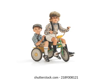 Cute Happy Kid Riding Tricycle Isolated On White Studio Background. Retro Vintage Style Concept. Friendship, Hobbies, Art, Eras Comparison And Children Emotions