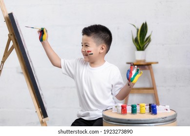 Cute Happy Little Asian Boy Painting With Water Color On Canvas Standing In White Room At Home, Creative Young Artist At Work. Kids Paint. Children Draw.