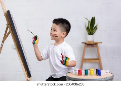 Cute happy little Asian boy painting with water color on canvas standing in white room at home, creative young artist at work. Kids paint. Children draw. - Powered by Shutterstock