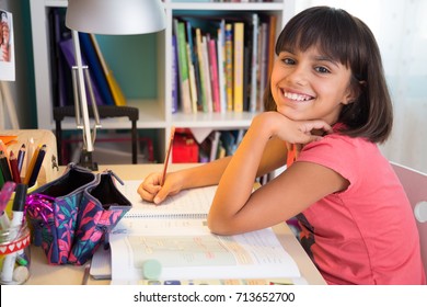 Cute Happy School Girl Doing Homework At Home