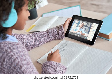 Cute Happy Smiling African American Black Schoolgirl Kid Holding Tablet, Writing Test Maths, Learning Online At Home, Talking With Teacher Tutor In Virtual Classroom.