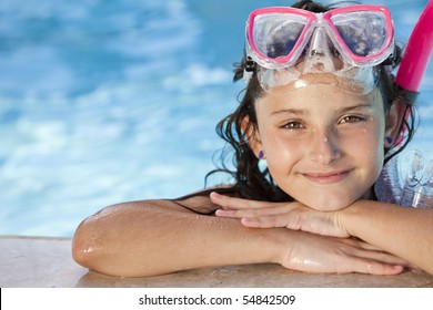 A cute happy young girl child relaxing on the side of a swimming pool wearing pink goggles and snorkel - Powered by Shutterstock