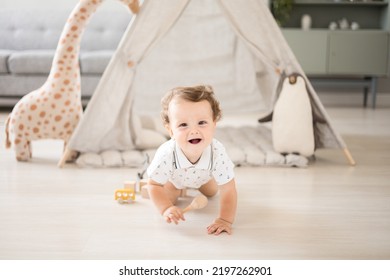 a cute healthy baby boy in a spacious bright children's room at home with a wigwam, soft toys, children's textiles. A child is playing in the living room of the house - Powered by Shutterstock