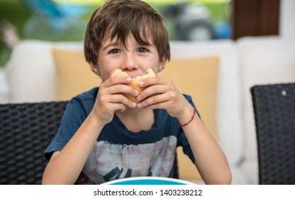 Cute Healthy Kid Boy Happy To Eat A Sandwich With Ham At Home. Happy Child Eating Healthy Organic Hamburger And Vegan Food. Childhood, Health Concept.