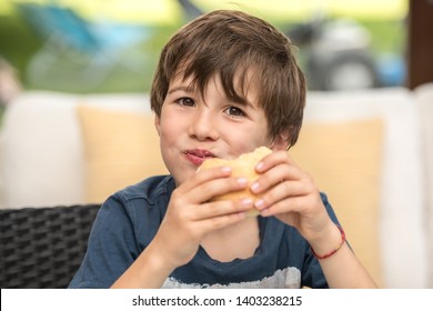 Cute Healthy Kid Boy Happy To Eat A Sandwich With Ham At Home. Happy Child Eating Healthy Organic Hamburger And Vegan Food. Childhood, Health Concept.