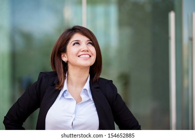 Cute Hispanic - Asian Businesswoman Smiling And Looking Up Towards Copy Space