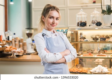 Cute Hispanic Female Business Owner Standing In Front Of Her Cake Shop And Smiling