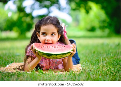 Cute Hispanic Girl Eating Watermelon At Park