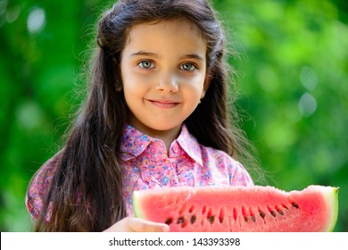 Cute Hispanic Girl Eating Watermelon At Park