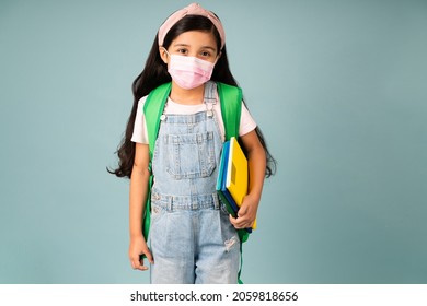 Cute Hispanic Girl With A Face Mask Making Eye Contact And Going To School During The Covid Pandemic