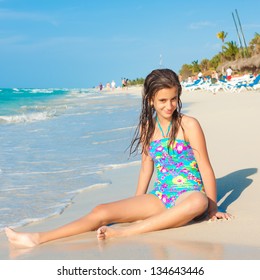 Cute hispanic teen playing with the waves on a beautiful beach in Cuba