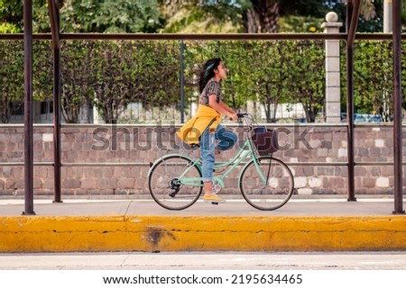 Cute Hispanic woman  riding a bike in the city.