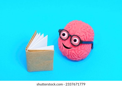 Cute human brain character wearing glasses, wholeheartedly immersed in a book. Pleasure of discovering new ideas.