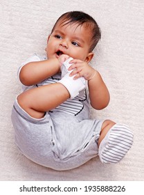 Cute Indian Baby Boy Lying On A Soft Baby Towel And Biting Own Feet