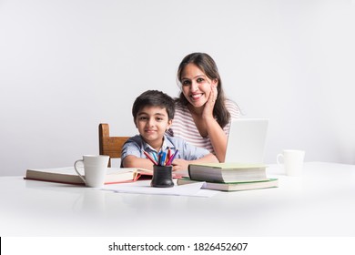 Cute Indian Boy With Mother Doing Homework At Home Using Laptop And Books - Online Schooling Concept