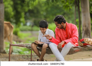 Cute Indian Child Studying With His Father At Home