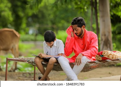 Cute Indian Child Studying With His Father At Home