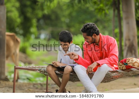 Cute indian child studying with his father at home
