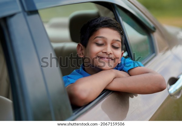 Cute Indian Child\
waving from car window.