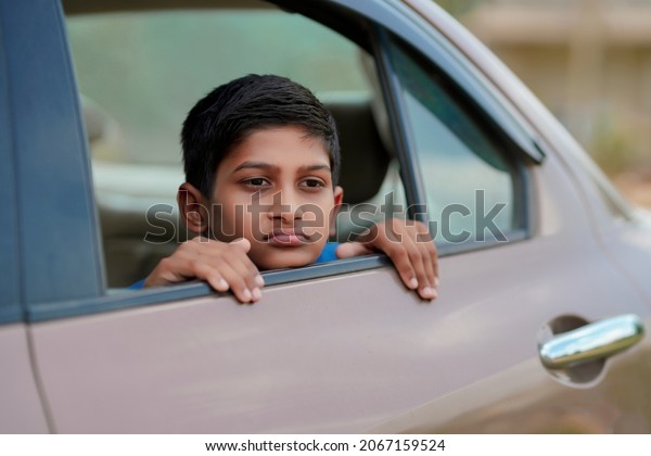 Cute Indian Child\
waving from car window.