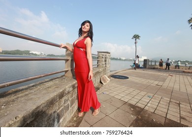 Cute Indian Female Model Wearing Red Long Dress Posing Outdoor In Daylight
