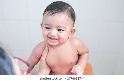 A Cute Indian Innocent New Born Baby In A Jovial Mood With A Charming Smile With Drops Of Water On His Body During Shower.