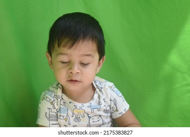  Cute Indian Little Baby Boy Face With Closed Eyes. Portrait Of Child On Green Background - Close-up. Sleeping Little Cute Human Child Closed Eye Face.