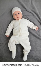 Cute Infant Baby On Gentle And Fluffy Blanket. Soft Fabric Background. Smiling Newborn Baby Boy. Family Morning At Home.