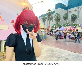 cute Japan anime cosplay, portrait of a girl with the red beryl comic costume, a cosplay girl with red wig and black mask. - Shutterstock ID 2175277993