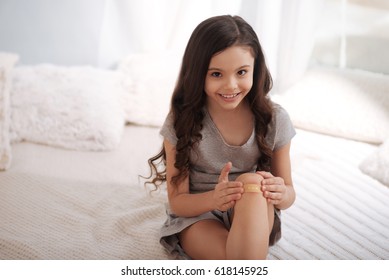 Cute Kid Applying Band Aid On Wound At Home