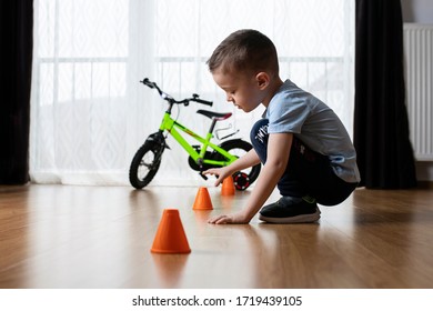 Cute Kid Assembling Track Inside The House For His Bike With Orange Cons