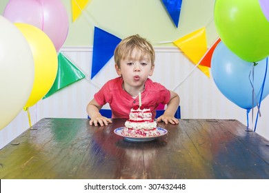 Cute Kid Blowing Out A Birthday Candle