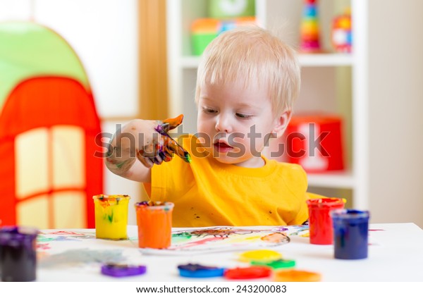 cute kid boy\
painting at home or\
playschool
