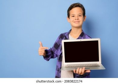 Cute kid boy in plaid shirt pointing finger to laptop screen isolated over purple background. - Powered by Shutterstock