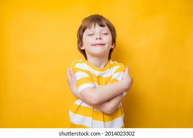 Cute Kid Boy Smiling With Pleasure While Embracing Himself, Keeping Arms Around His Shoulders. Body Positive, Self Acceptance, Self Esteem Concept