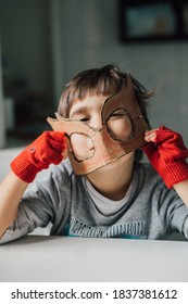 Cute Kid In Disguise With DIY  Cardboard Superhero Mask At Home. Boy With Creative Halloween Costume Or Festive Apparel For Children Theater. Playful Spirit Concept. Home Celebration With Family.