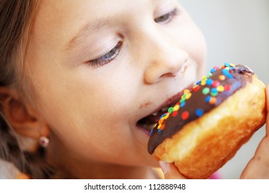 Cute Kid Girl Eating Sweet Donuts