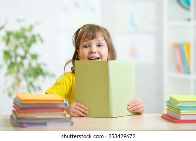 cute kid girl with open book studying in primary school - Shutterstock ID 253429672