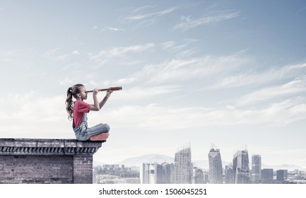 Cute Kid Girl Sitting On House Roof And Looking In Spyglass