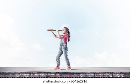 Cute Kid Girl Standing On House Roof And Looking In Spyglass