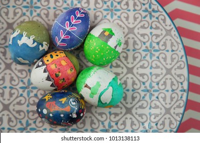 Cute kid Hand painted easter eggs on a patterned plate