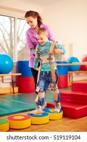 Cute Kid Having Physical Musculoskeletal Therapy In Rehabilitation Center