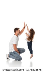 Cute Kid Jumping While Giving High Five To Happy Father On White