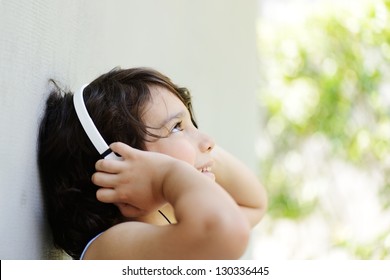 Cute Kid Listening To Music On Headphones And Enjoying